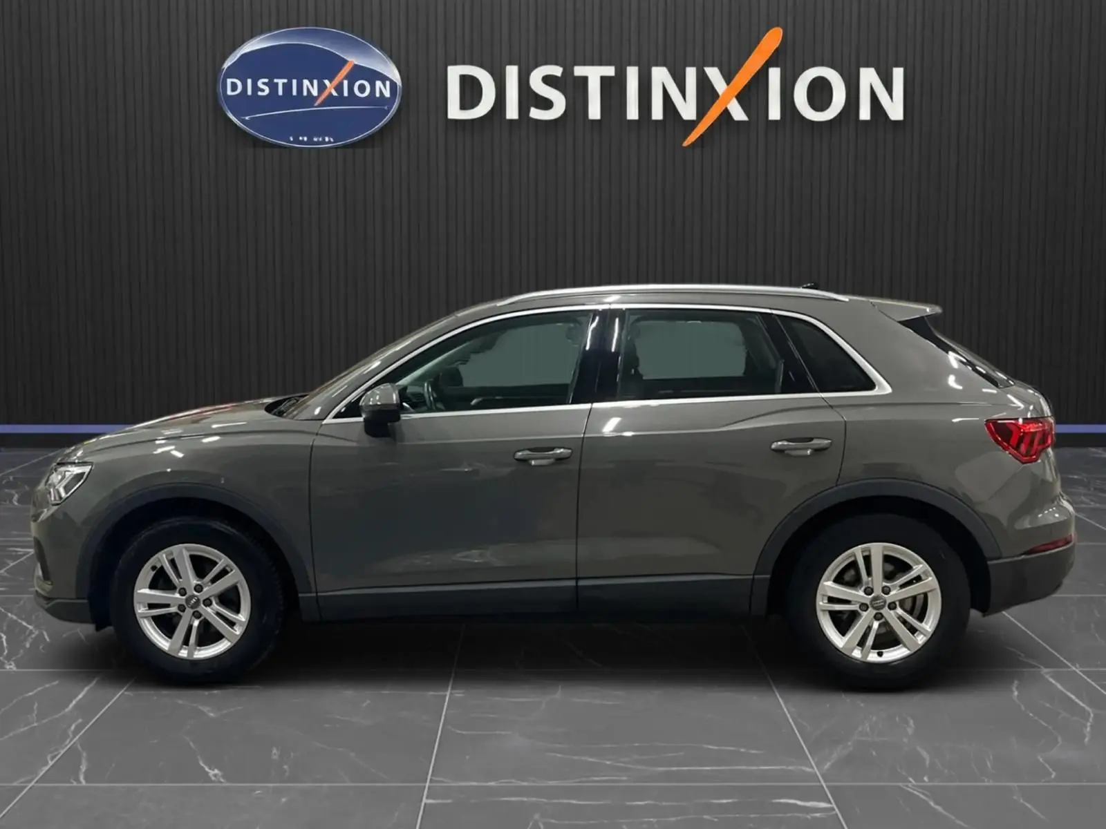 Profil droit d'un Audi Q3 Business gris 2019, mettant en valeur ses jantes alliage et feux arrière LED.