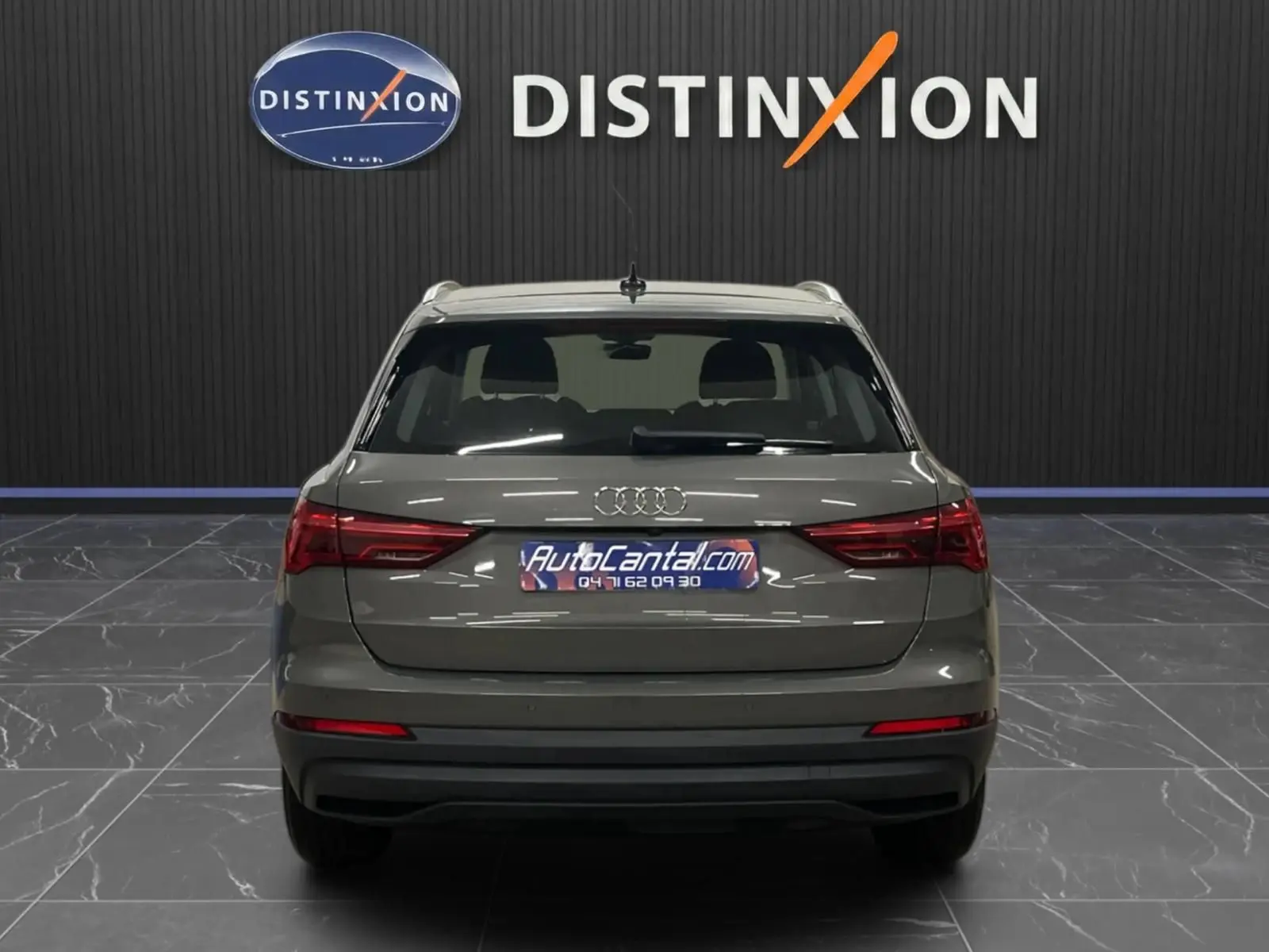 Vue arrière d’un Audi Q3 Business gris avec feux arrière LED dynamiques dans un showroom.