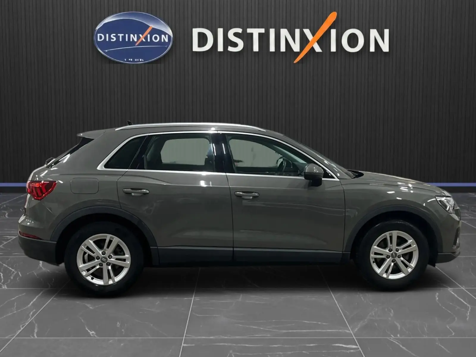 Vue latérale droite d'un Audi Q3 Business gris de 2019 avec jantes alliage et feux arrière LED dynamiques.