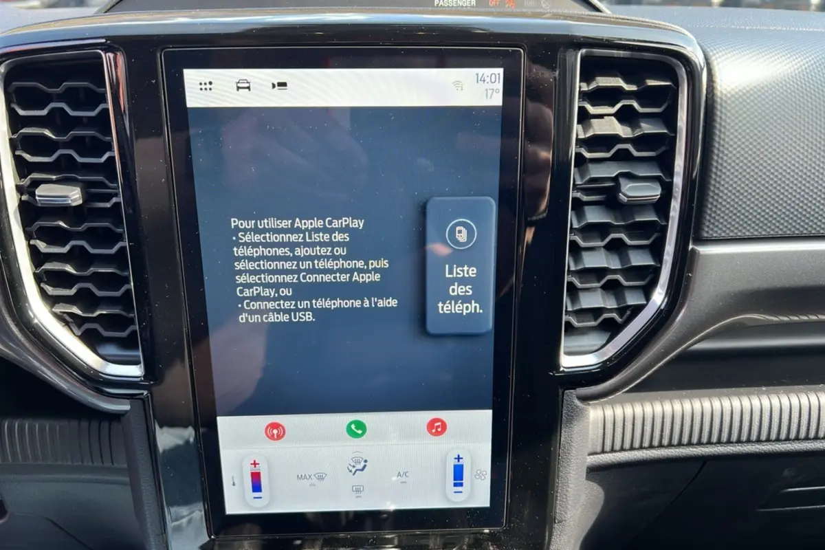 Écran tactile central du Ford Ranger 2025 affichant les instructions Apple CarPlay, entouré de la console noire et des aérateurs.