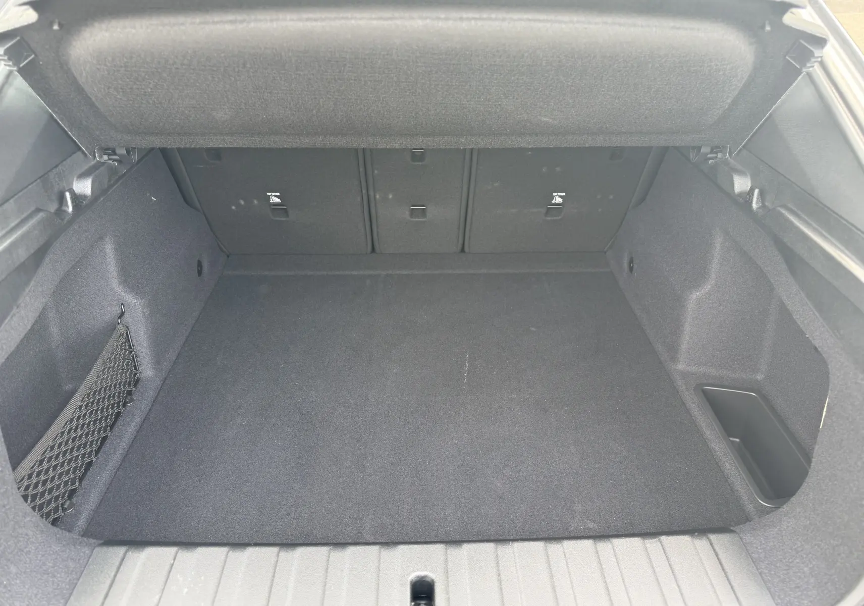 Coffre ouvert vu de l'arrière d'un BMW X2 2025, intérieur spacieux et revêtement noir sans chargement visible.