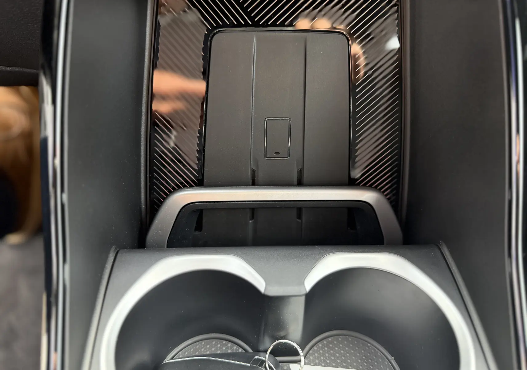Gros plan sur la console centrale du BMW X2 2025, avec porte-gobelets et surface noire à effet carbone.