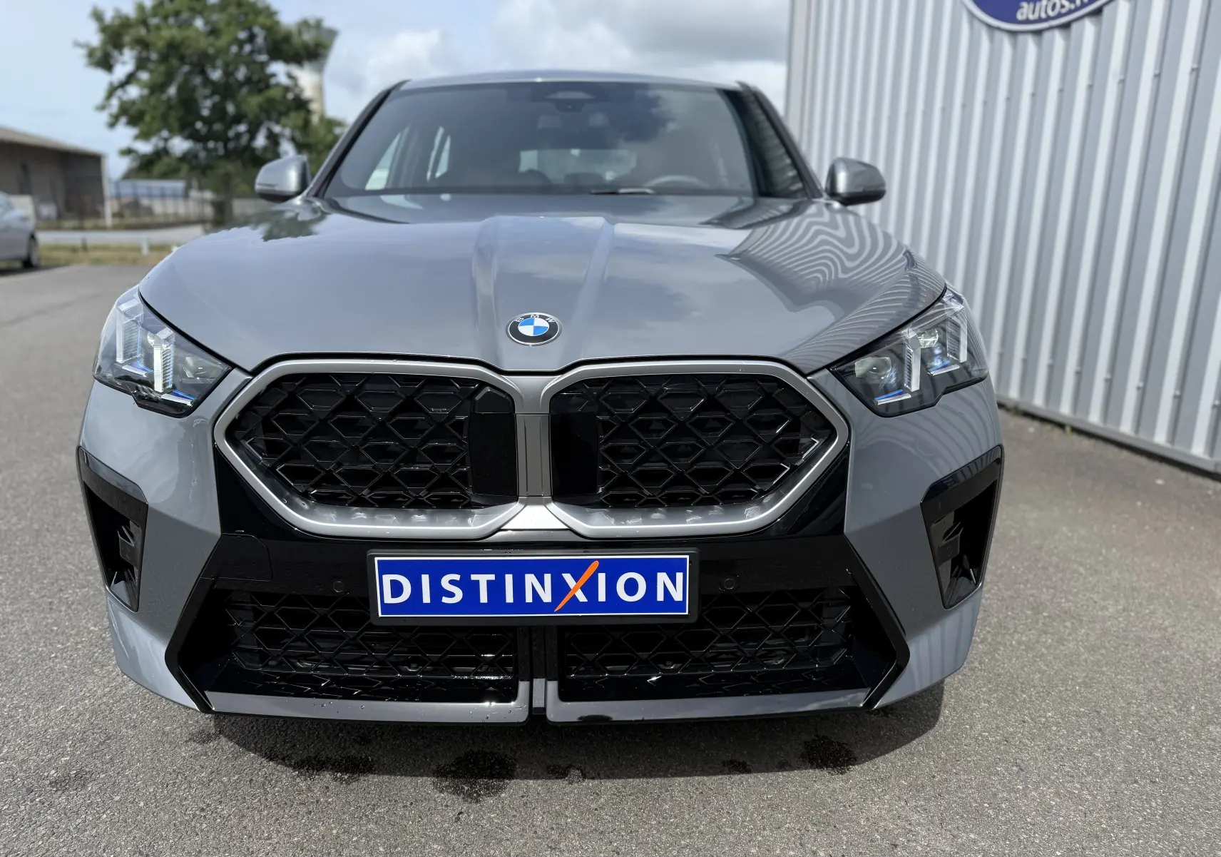 Vue avant rapprochée d’une BMW X2 2025 gris Skyscraper avec calandre noire et phares LED distinctifs.