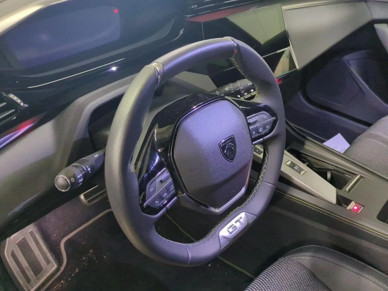 Vue intérieure centrée sur le volant cuir noir GT et la console centrale de la Peugeot 308 2025.