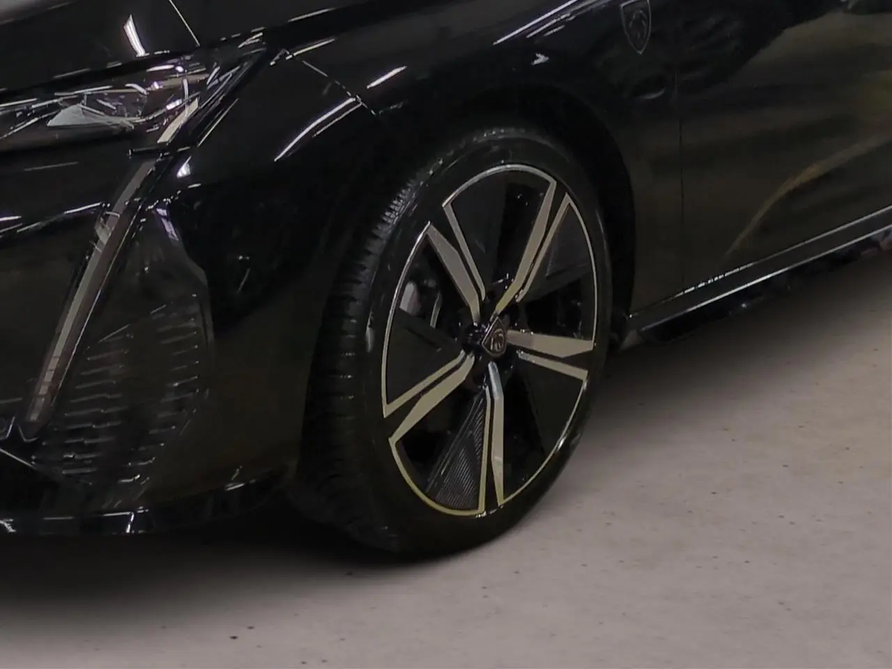 Gros plan sur la roue avant gauche et partie du pare-chocs noir Perla de la Peugeot 308 2025 avec jante alliage 18'' Kamakura.