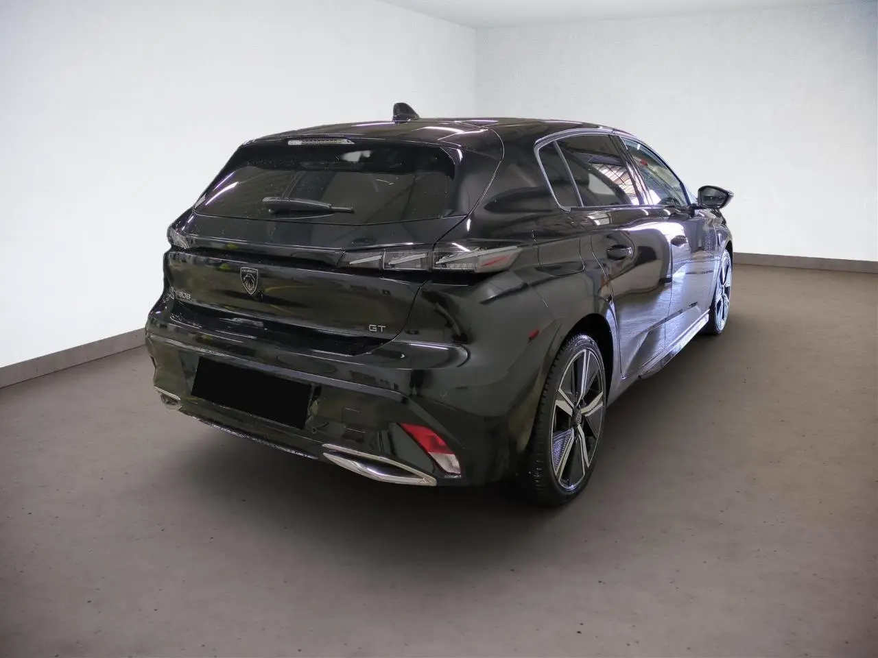 Vue 3/4 arrière droit d'une Peugeot 308 GT noire Perla avec jantes alliage 18 pouces et feux LED distinctifs.