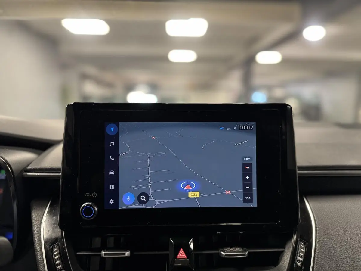 Écran tactile central affichant la navigation GPS dans l'habitacle d'une Toyota Corolla hybride gris 2022.