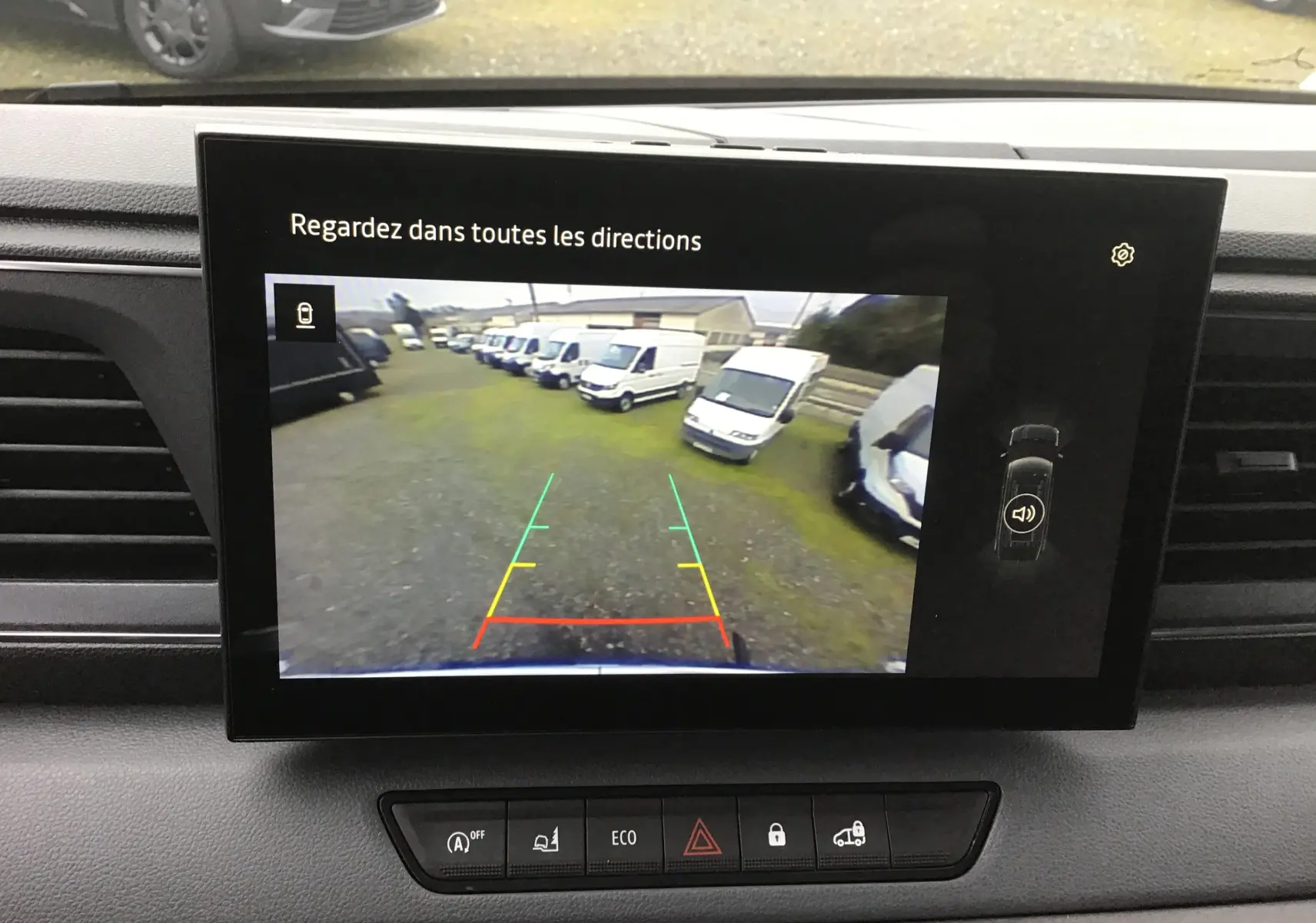 Écran central montrant la caméra de recul du Renault Master blanc, vue arrière avec plusieurs fourgons alignés.
