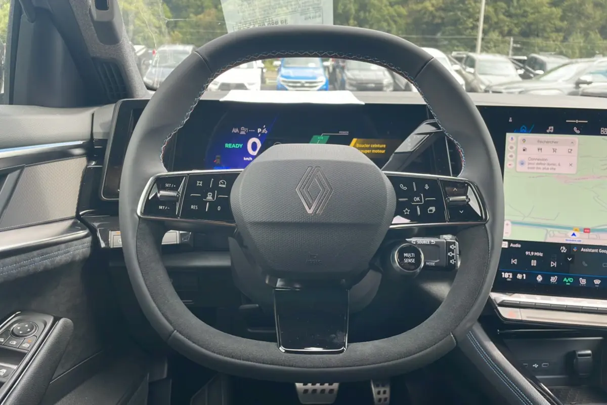 Vue intérieure centrée sur le volant en alcantara du Renault Austral New 200 Esprit Alpine avec tableau de bord numérique et écran tactile.
