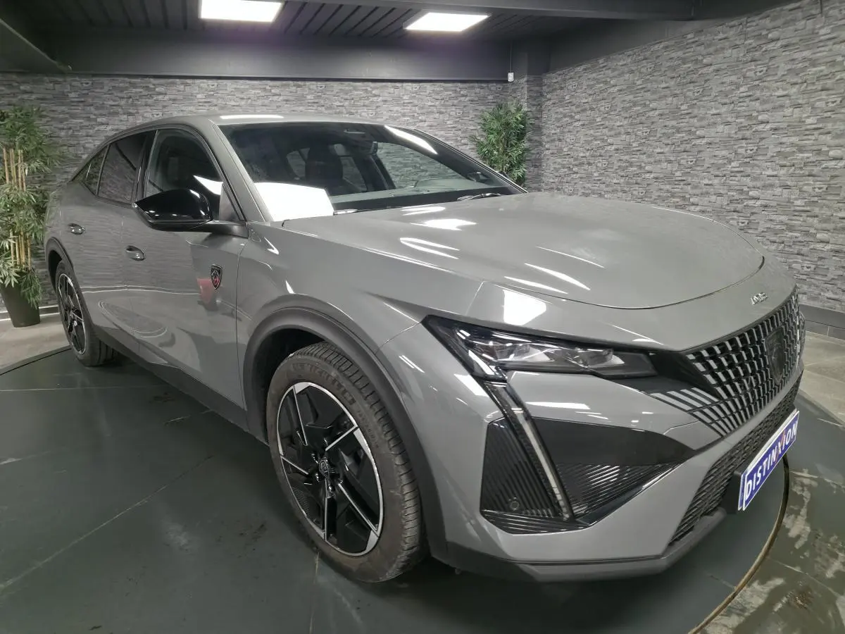 Vue 3/4 avant gauche de la Peugeot 408 gris métallisé avec calandre noire et jantes alliage 19 pouces diamantées.