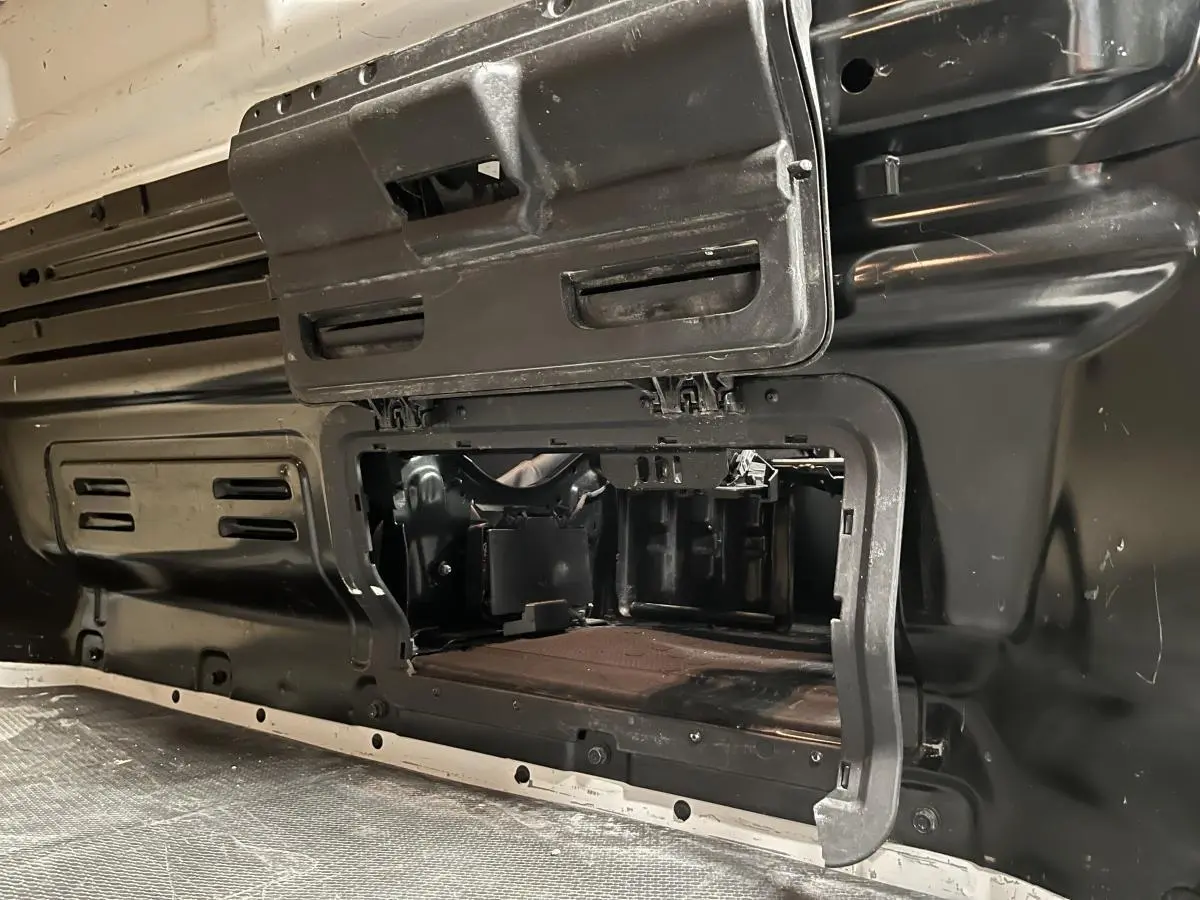 Détail de la cloison intérieure en bois noir du Nissan Primastar blanc, vue rapprochée de la zone de chargement