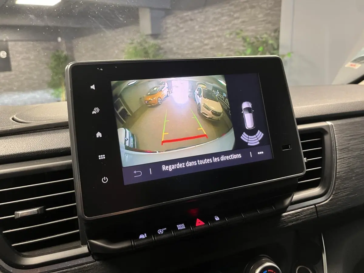 Écran tactile intérieur montrant la caméra de recul du Nissan Primastar blanc, avec vue arrière et aides au stationnement.