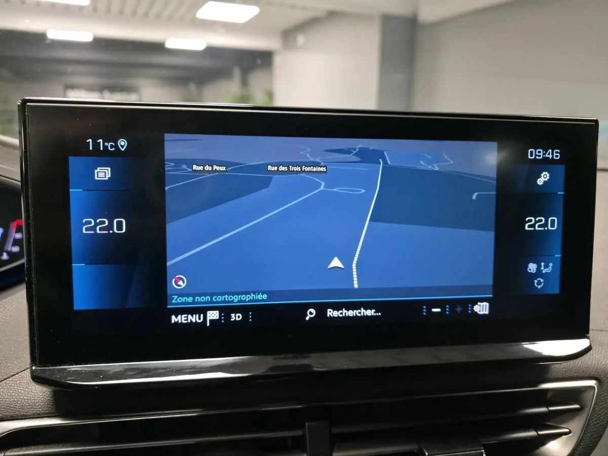 Écran tactile 10 pouces du tableau de bord du Peugeot 5008 gris, affichant la navigation GPS en intérieur.