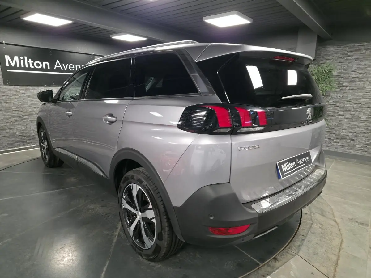 Vue 3/4 arrière droit du Peugeot 5008 gris métallisé avec jantes alliage bi-ton et vitres arrière surteintées.