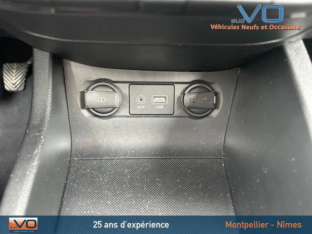 Prise USB, entrée auxiliaire et allume-cigare au centre console d'une Hyundai i20 blanche essence 2019.