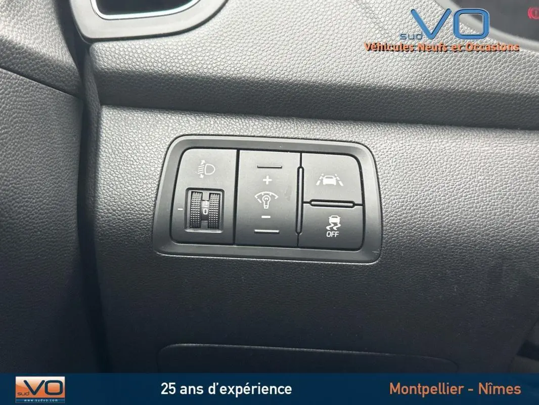Gros plan sur les commandes de réglage d'éclairage et d'aide à la conduite dans l'habitacle d'une Hyundai i20 blanche 2019.