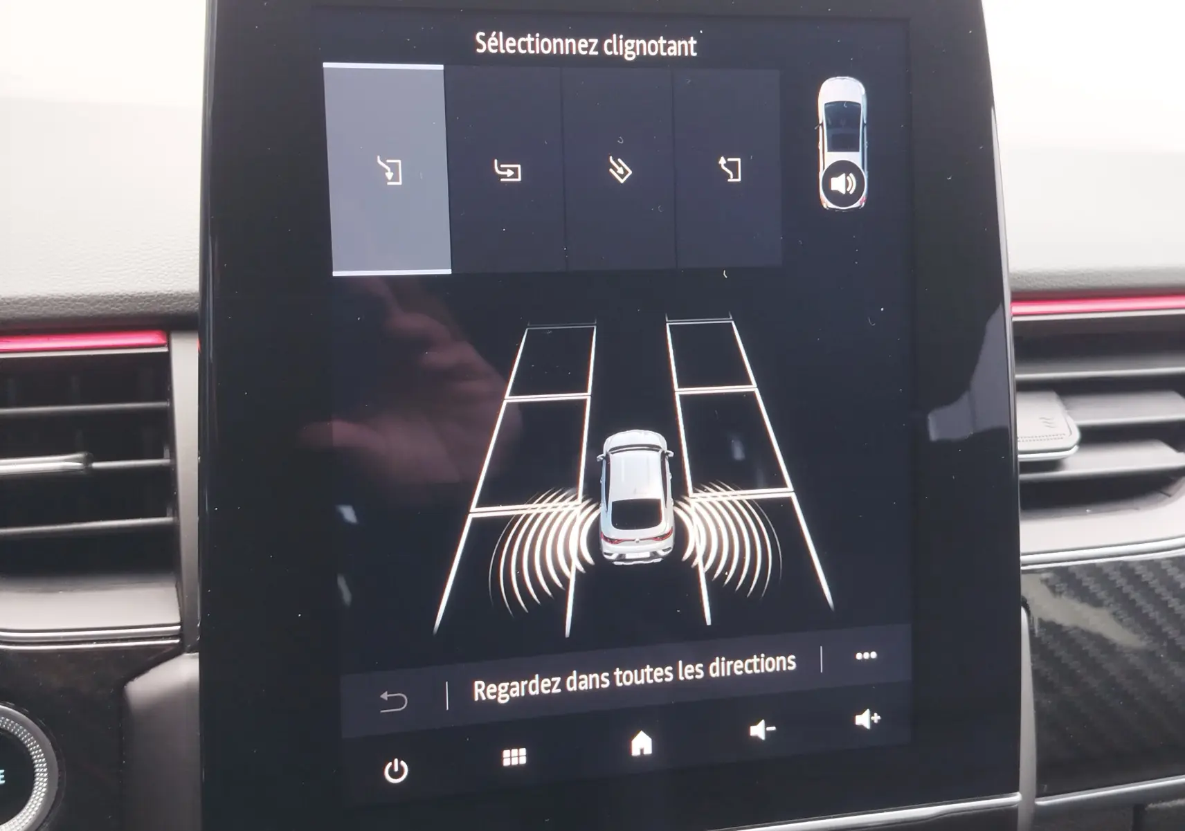 Écran central montrant l'aide au stationnement avec vue du dessus du Renault Arkana bleu Zanzibar en stationnement.