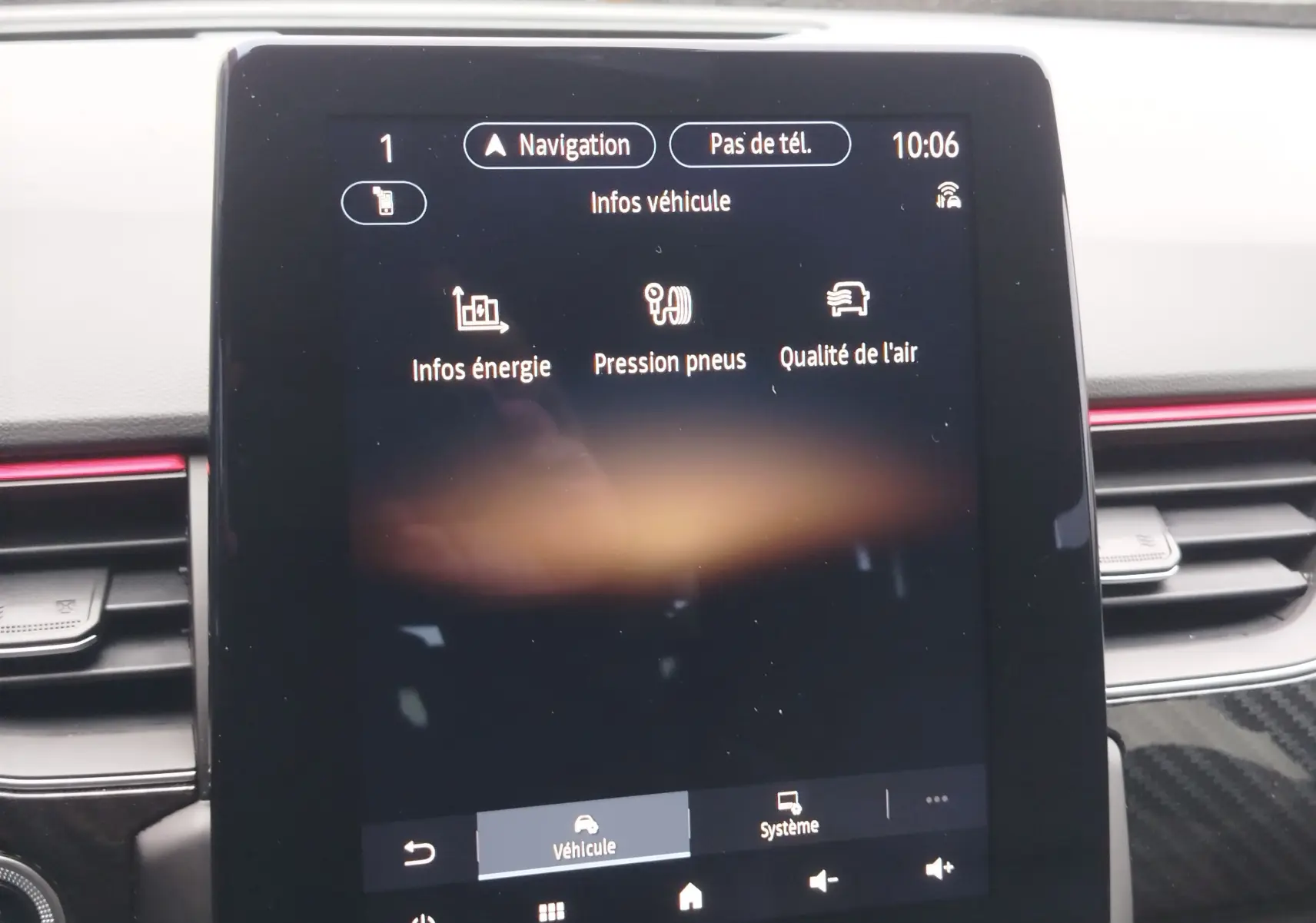 Écran tactile central du tableau de bord du Renault Arkana 2022 affichant les infos véhicule, entouré de garnitures noires et rouges.