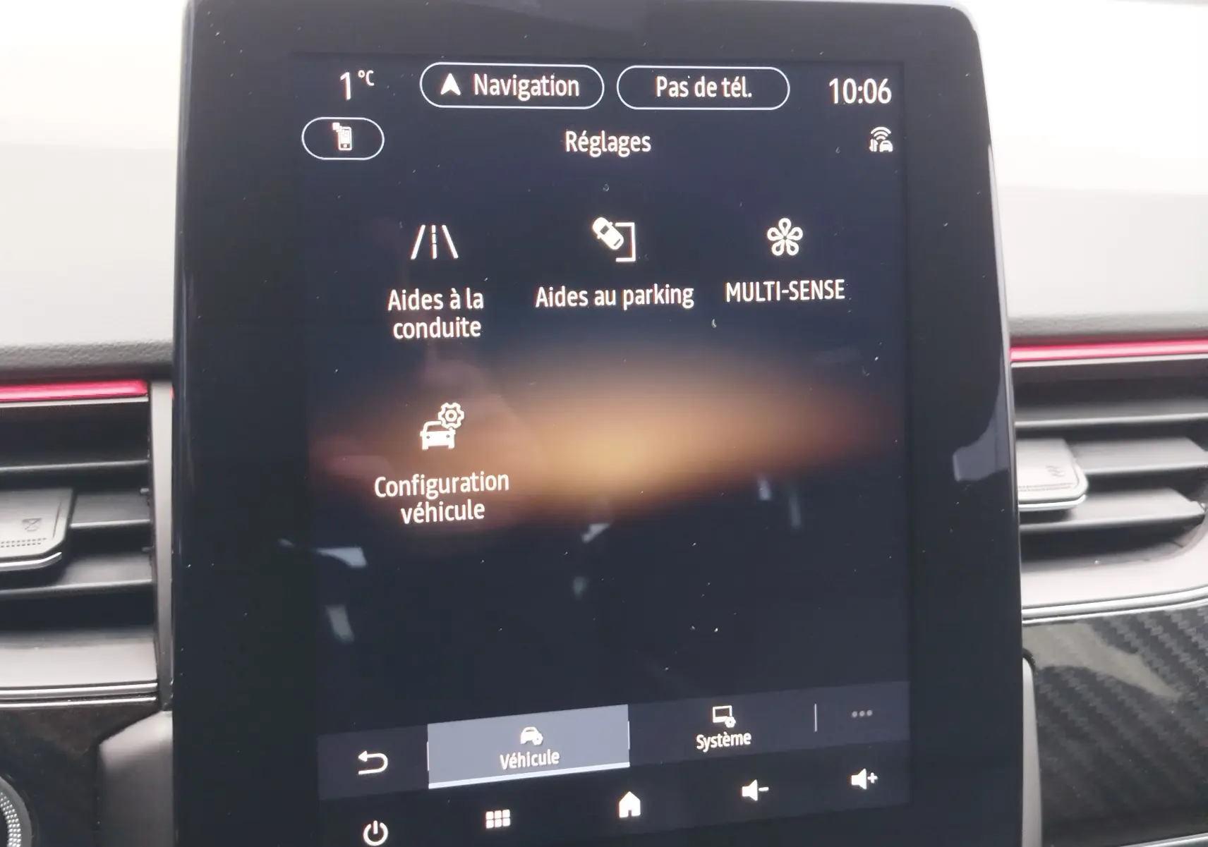 Écran tactile central du tableau de bord du Renault Arkana 1.6 E-Tech 145ch RS Line 2022 affichant les réglages d’aides à la conduite et parking.