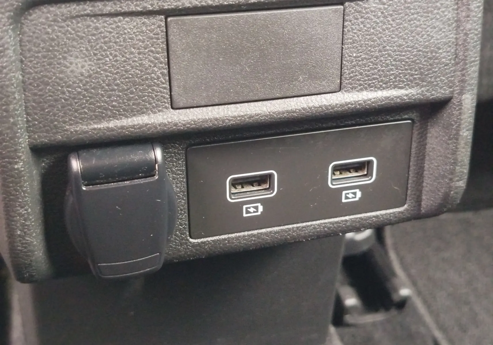 Prise USB double et prise 12V sur console centrale intérieure d’un Renault Arkana bleu Zanzibar 2022.