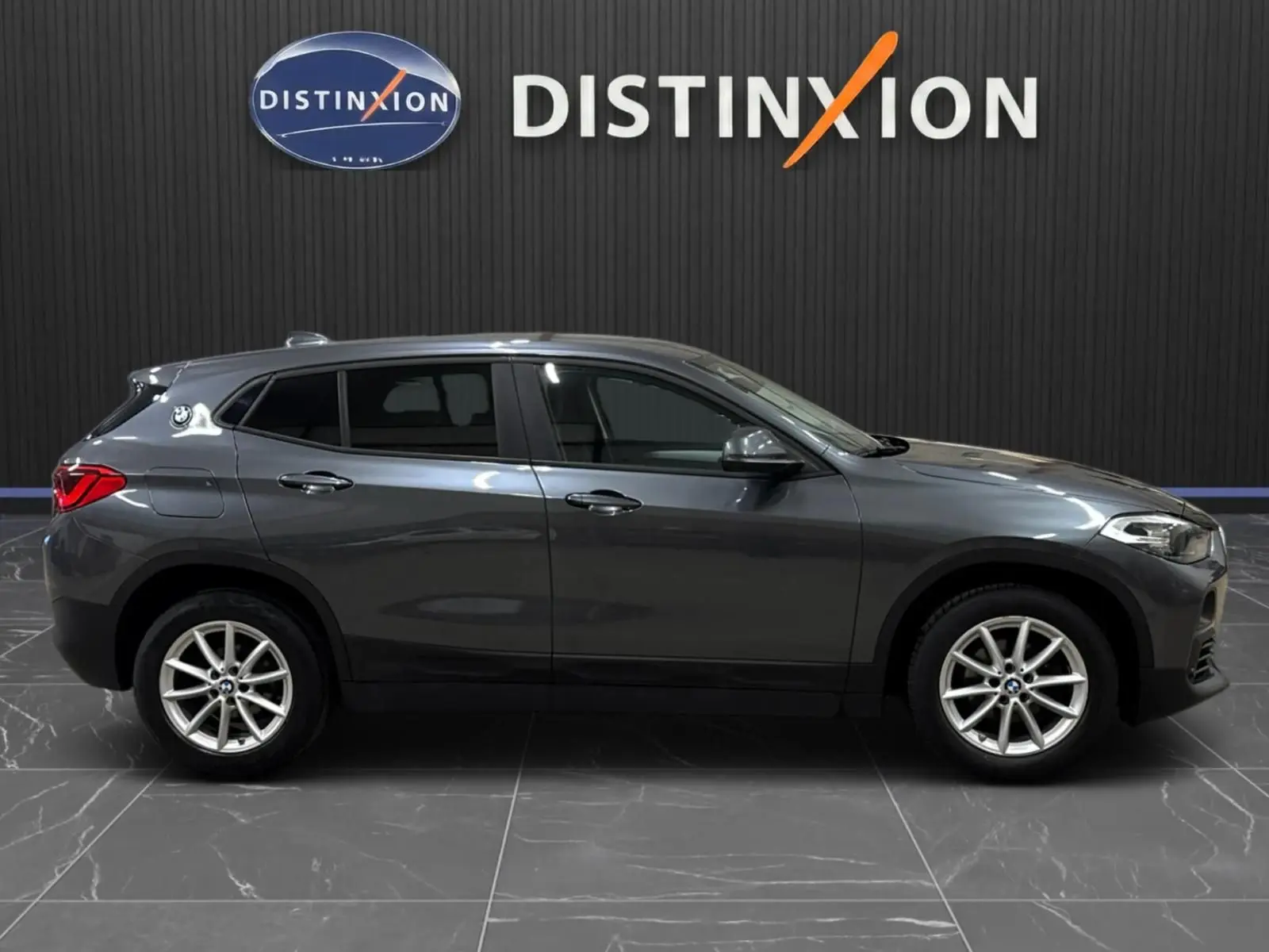 BMW X2 gris minéral métallisé vue de profil côté gauche, avec vitres arrière surteintées et jantes alliage.