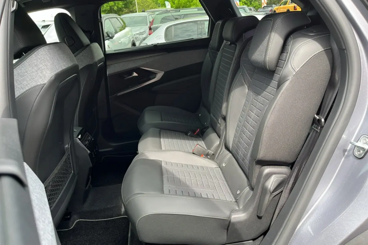 Vue intérieure côté droit des sièges arrière en tissu et cuir gris d'un Peugeot 3008 Hybrid 2025 gris titane.