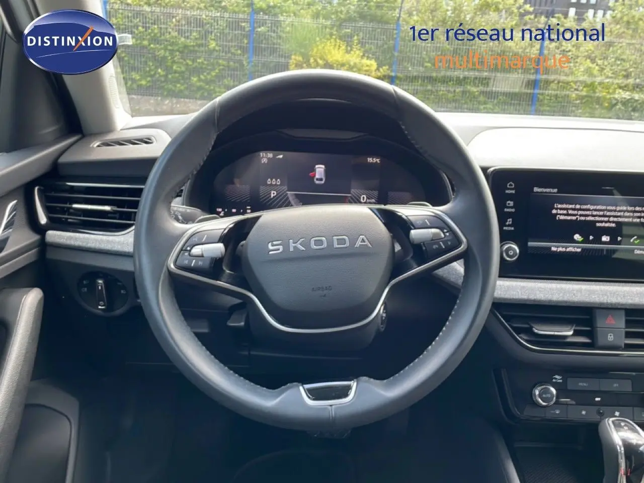 Vue intérieure centrée sur le volant SKODA d'une Scala 2025, avec tableau de bord digital et écran multimédia affichant la caméra de recul.