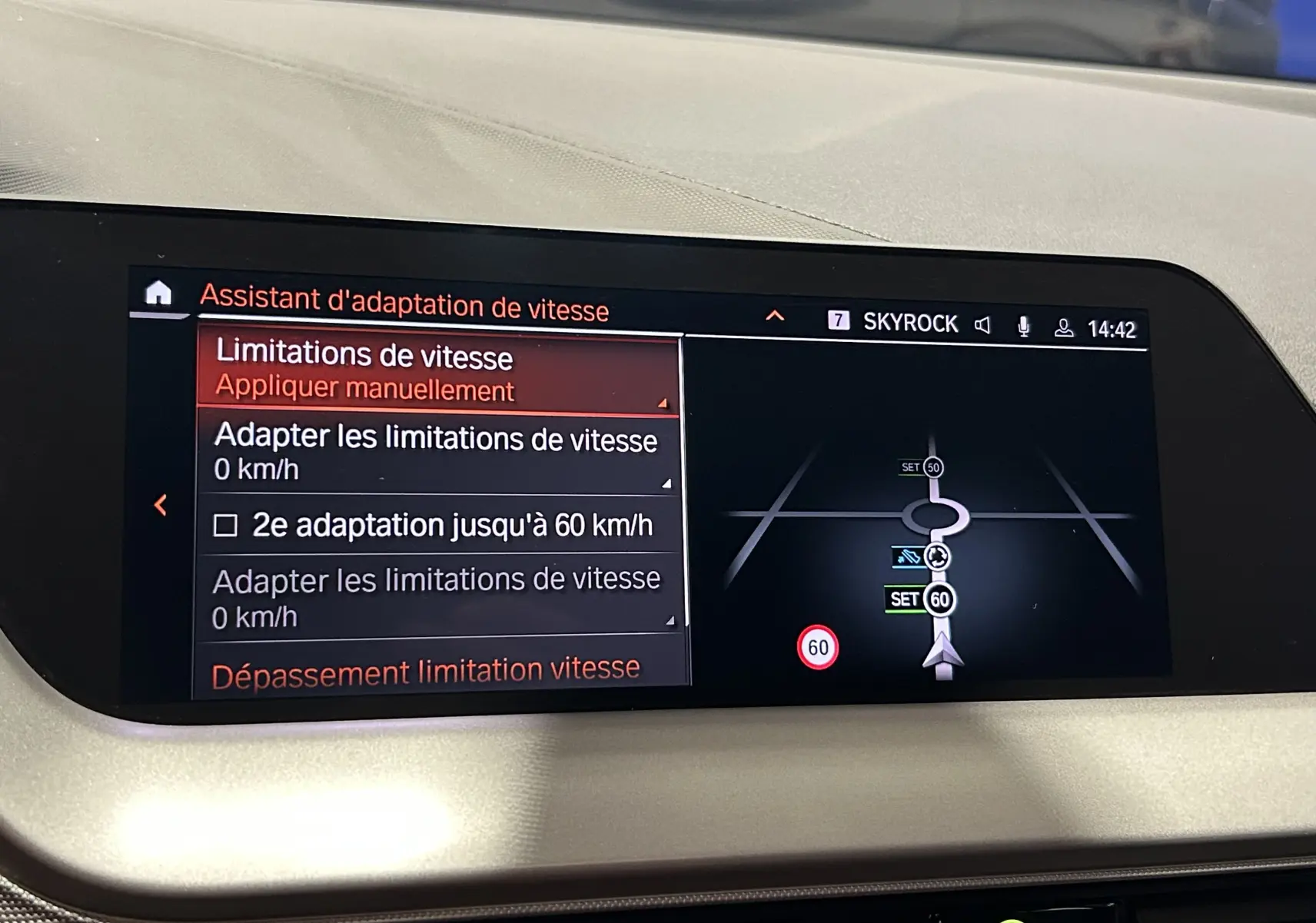 Écran central du tableau de bord d'une BMW Série 1 noire 2023 affichant l'assistant d'adaptation de vitesse et la navigation GPS.