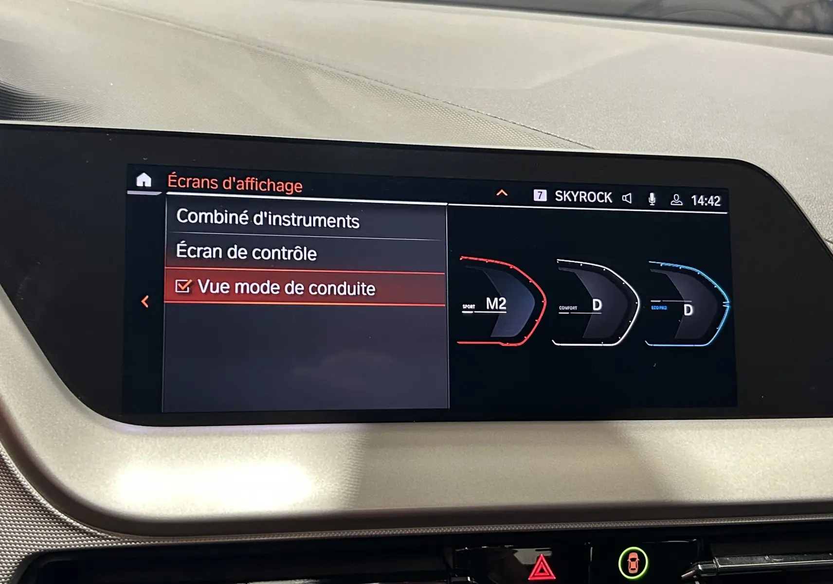 Écran central de la BMW Série 1 16d 2023 affichant les modes de conduite Sport, Confort et Eco en vue intérieure.