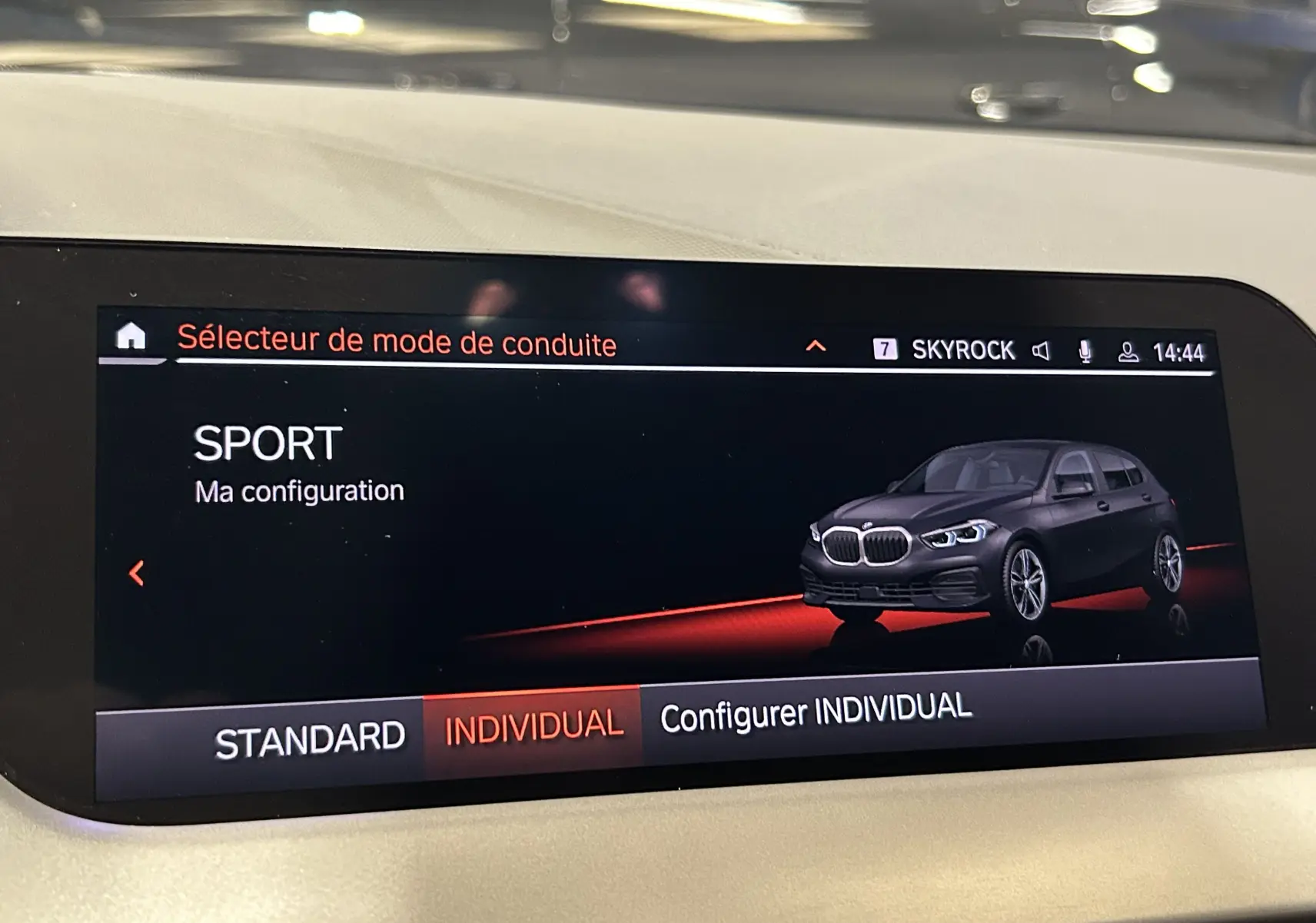 Affichage intérieur du mode de conduite SPORT avec illustration 3/4 avant d'une BMW Série 1 noire 2023