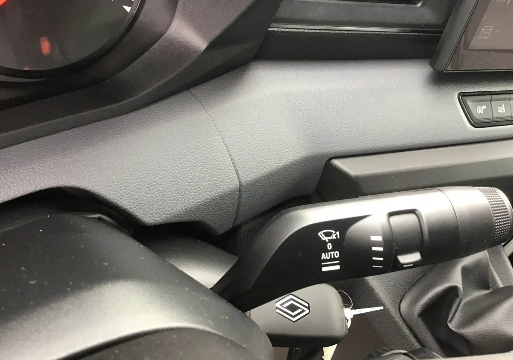 Gros plan sur la commande d’essuie-glace et la clé de contact dans l’habitacle gris du Renault Master L2H2 2025.