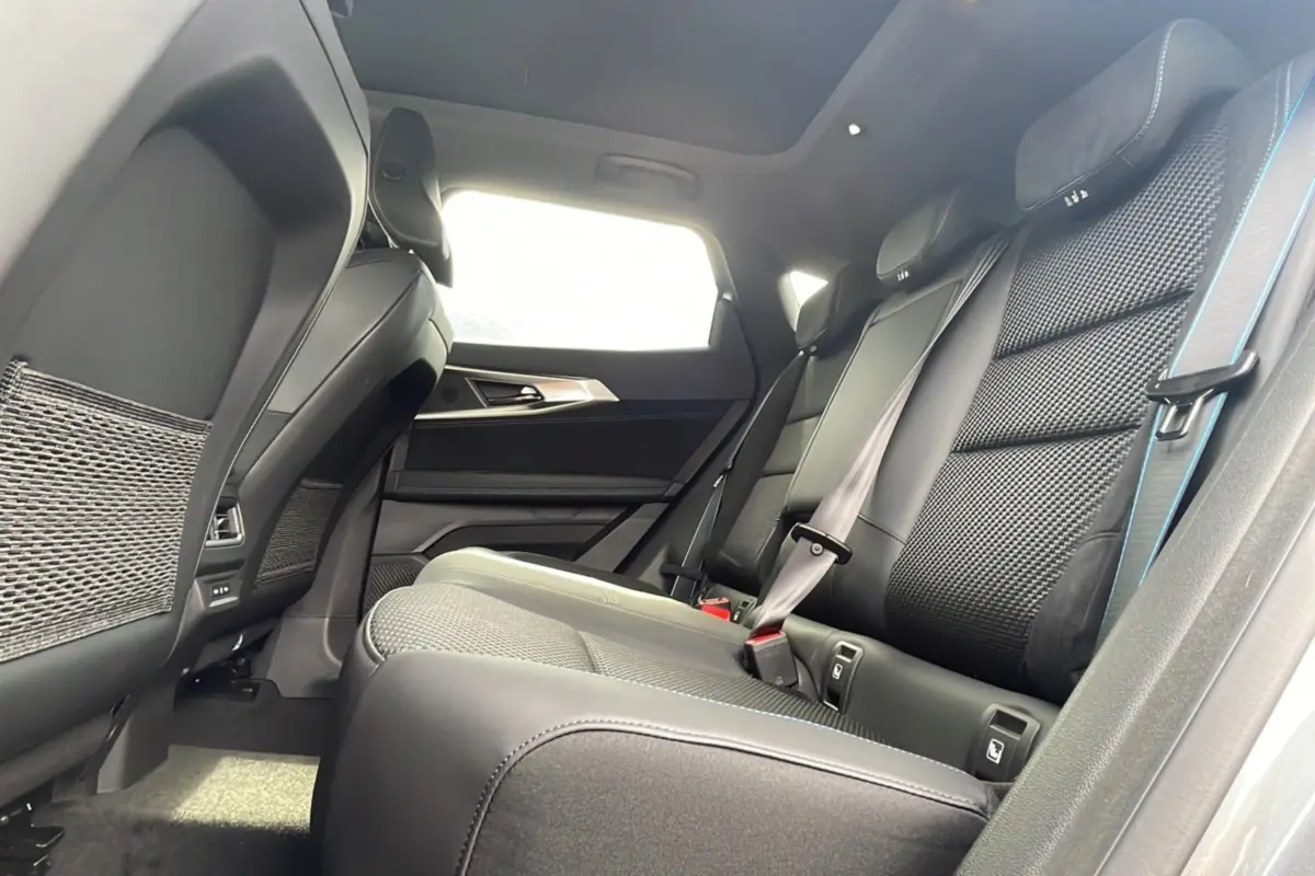 Vue intérieure arrière côté droit du Renault Austral New 200 Esprit Alpine avec sièges semi-alcantara noirs et toit panoramique.