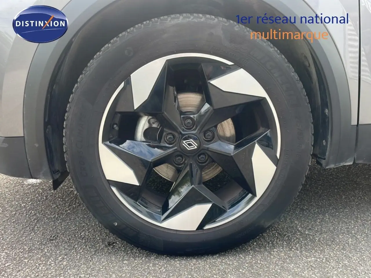 Gros plan sur la roue avant gauche du Renault Captur gris Cassiopée métal avec jante diamantée noire et argentée.