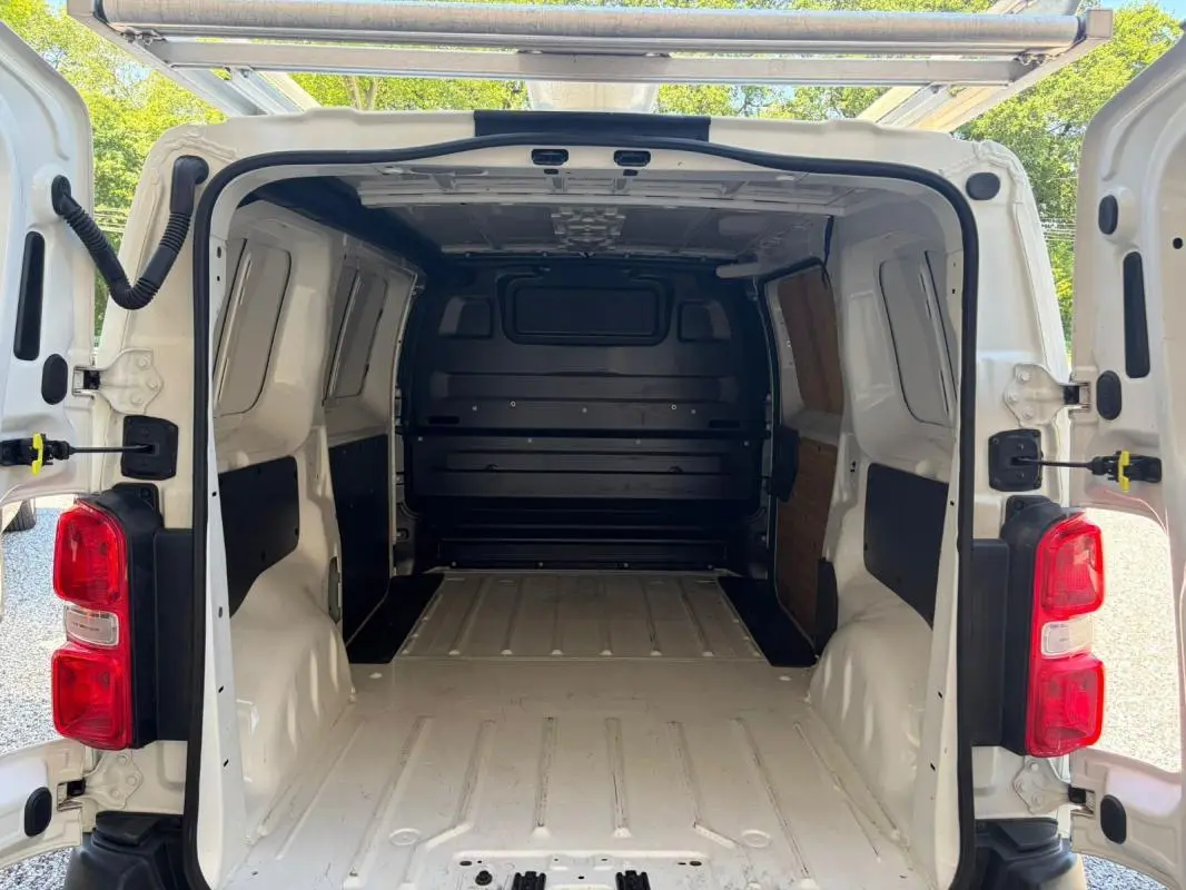 Vue arrière ouverte du Peugeot Expert Fourgon blanc 2019 montrant l’espace de chargement vide et les portes battantes ouvertes.