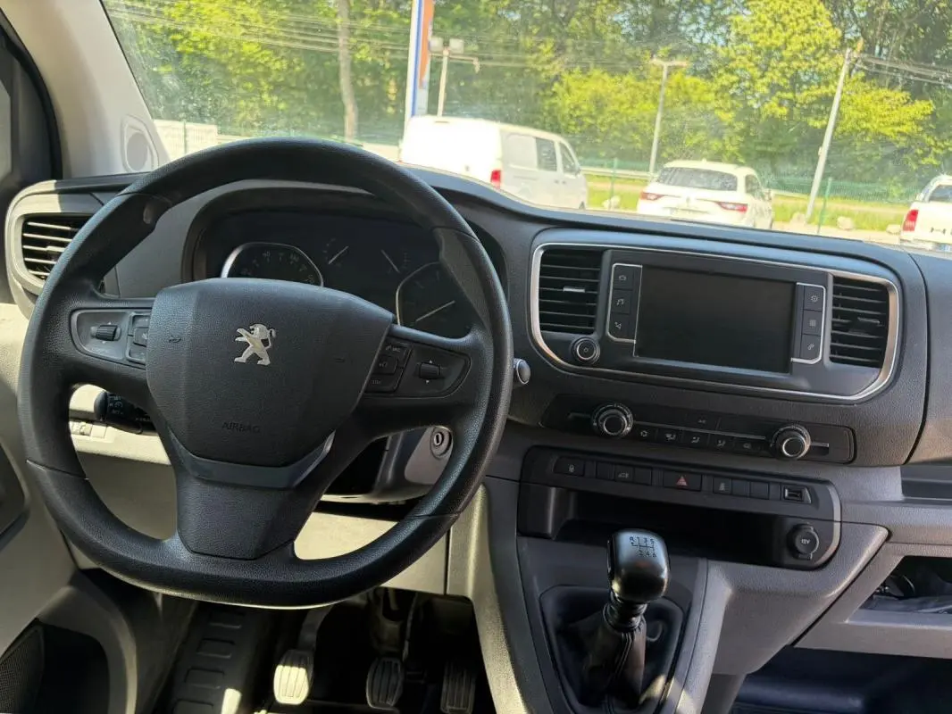 Vue intérieure du tableau de bord du Peugeot Expert Fourgon blanc, volant cuir multifonctions et levier de vitesse manuel visibles.
