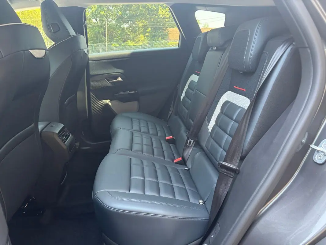 Vue latérale droite de la banquette arrière en cuir noir du Citroën C5 Aircross gris 2026 avec ceintures et appuie-têtes.