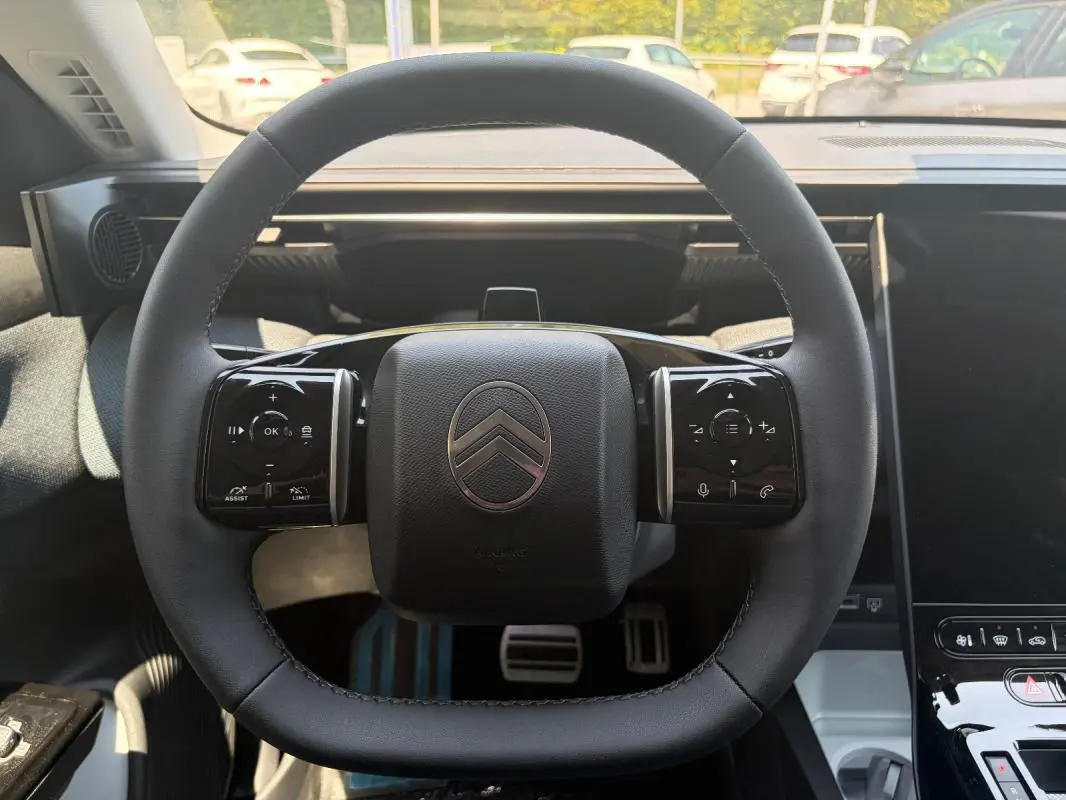 Vue rapprochée du volant cuir multifonctions du Citroën C5 Aircross gris 2026 avec commandes intégrées.