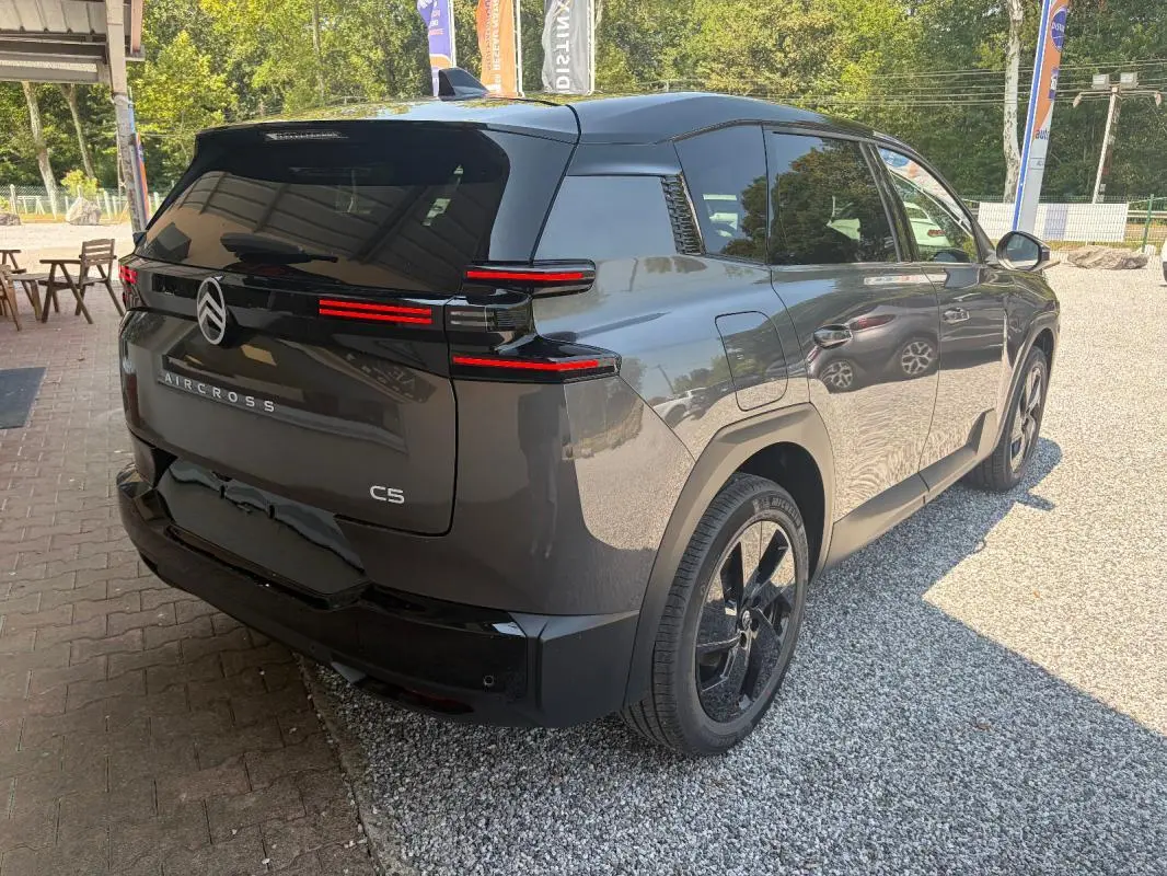 Vue 3/4 arrière droite d'un Citroën C5 Aircross gris 2026 avec feux arrière LED et jantes noires 19 pouces.