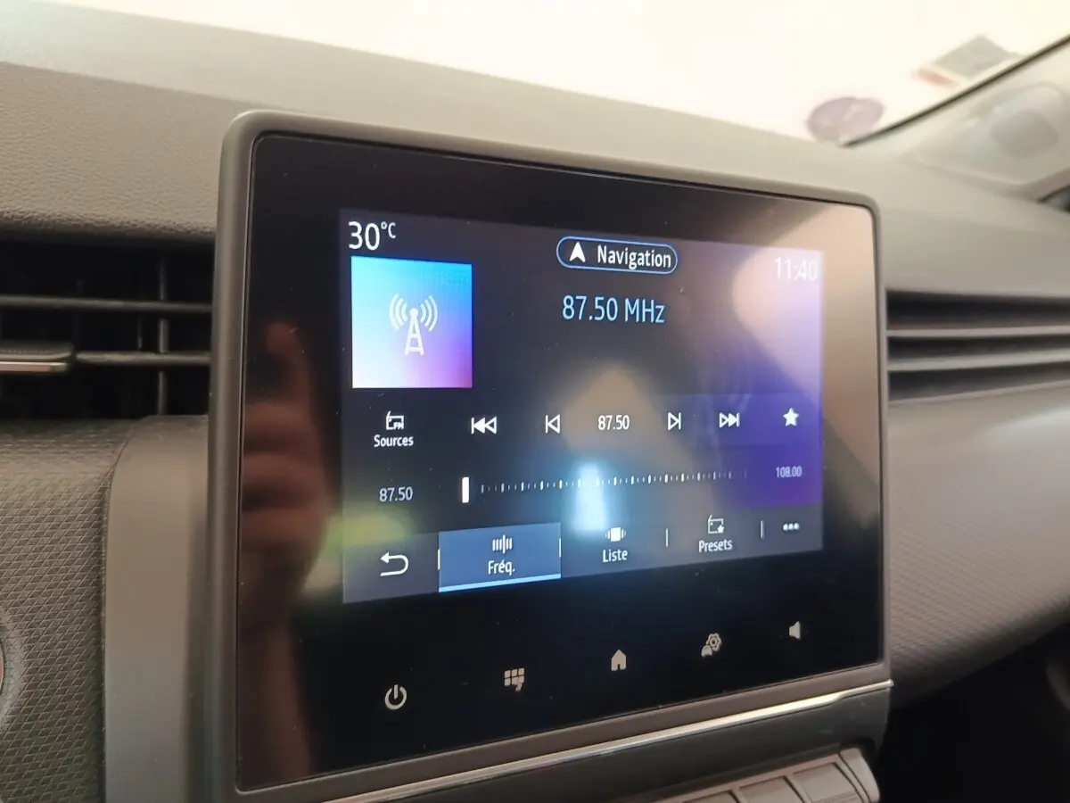 Écran tactile central de la Renault Clio Business gris clair, affichant la radio à 87,50 MHz en intérieur.