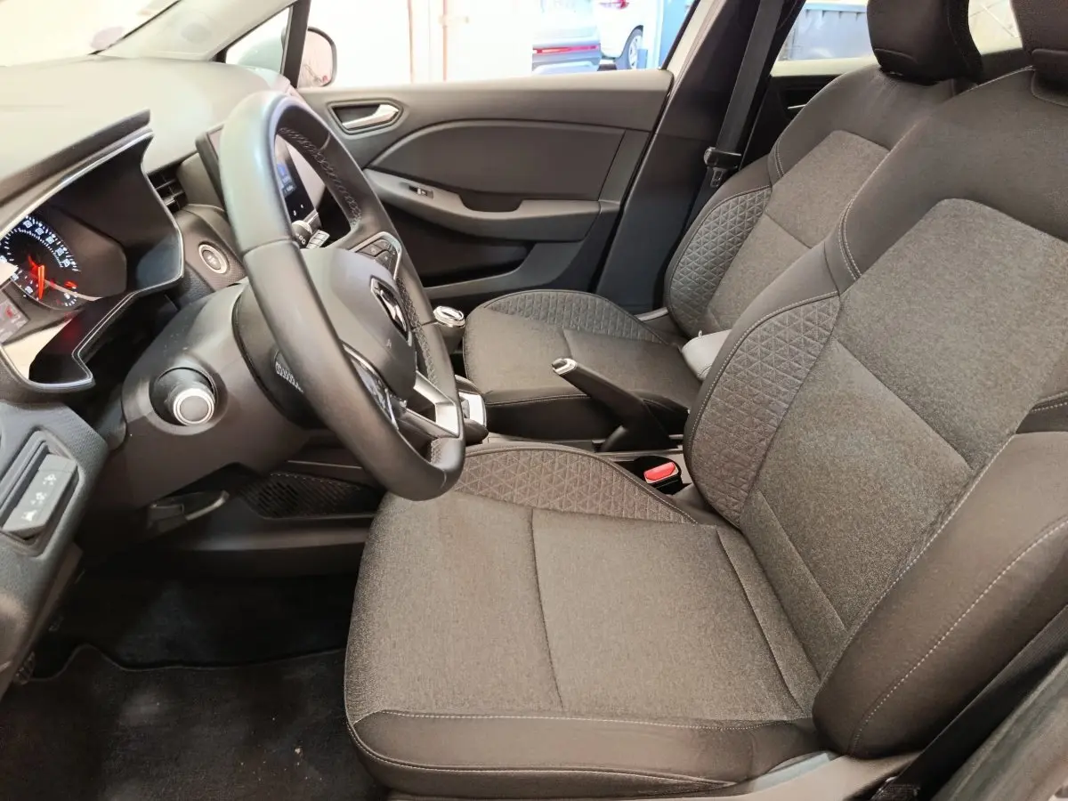 Vue intérieure côté conducteur de la Renault Clio Business TCe 100 2021 avec sièges gris et volant cuir multifonctions.