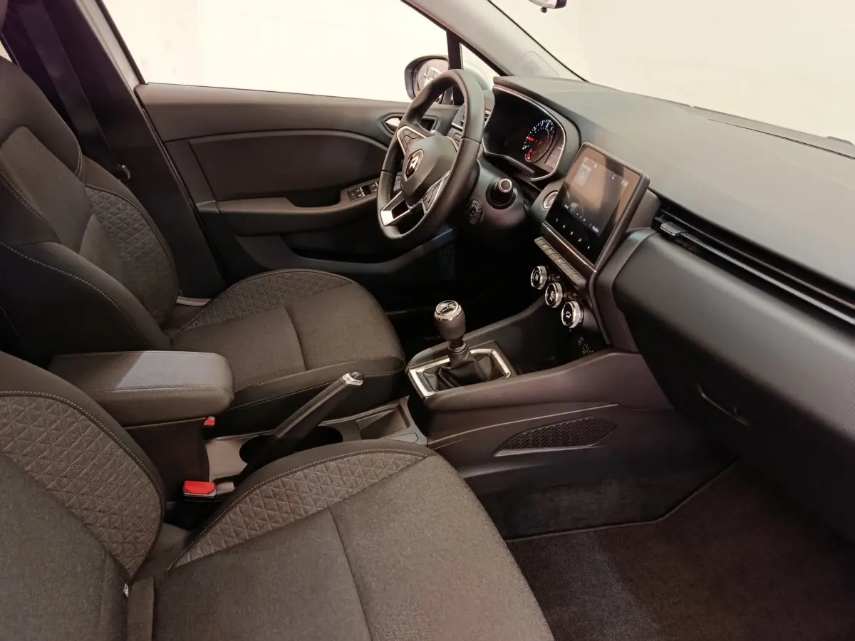 Vue intérieure côté conducteur de la Renault Clio Business 2021, volant cuir multifonctions et levier de vitesse manuel visibles.