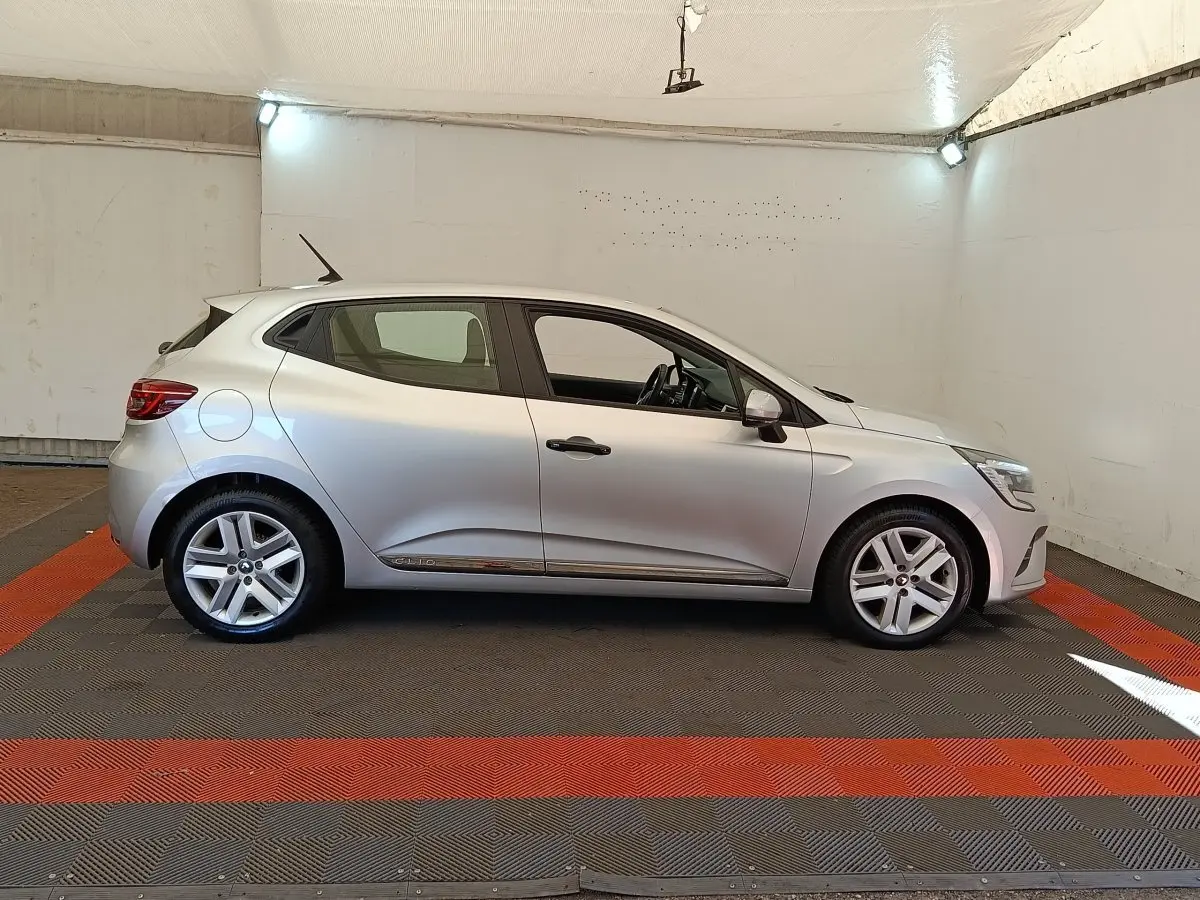 Profil droit d'une Renault Clio Business TCe 100 gris clair, avec jantes alliage et poignées de porte noires.