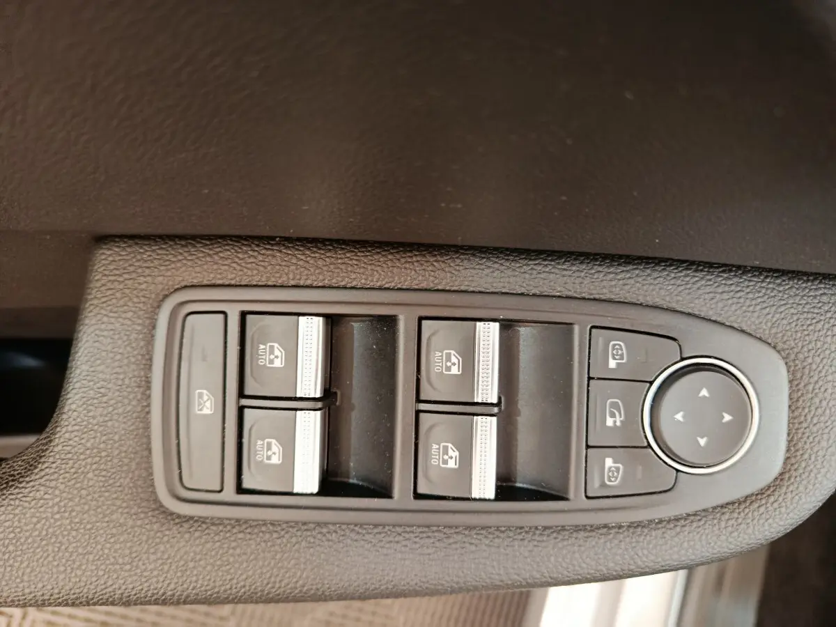 Gros plan sur les commandes des vitres électriques et rétroviseurs, intérieur noir de la Renault Clio Business TCe 100 2021.