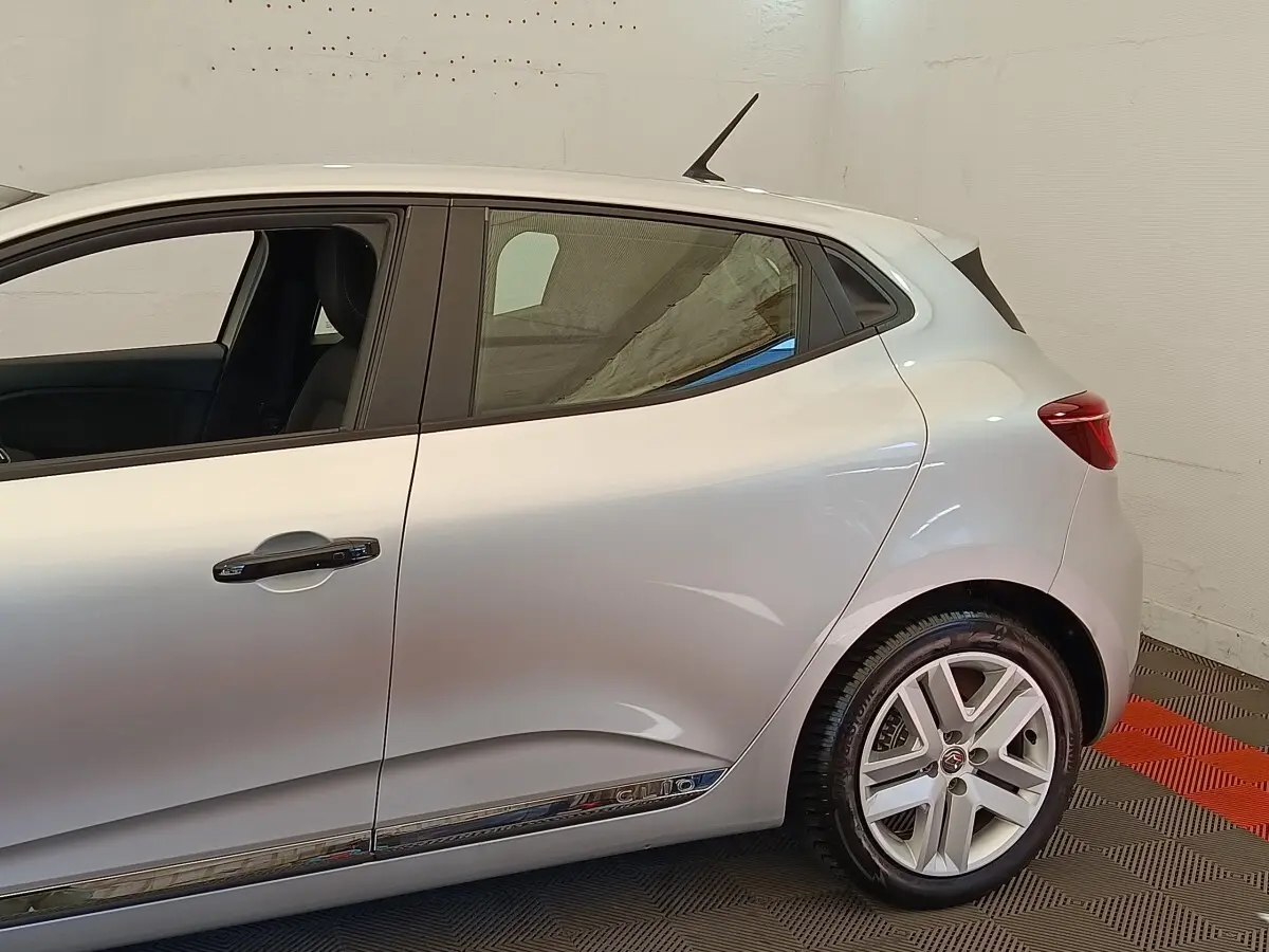 Profil côté gauche de la Renault Clio Business TCe 100 gris clair, avec jante alliage et poignées de porte chromées.
