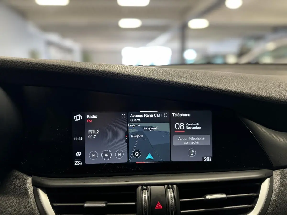 Écran tactile panoramique 8,8" du tableau de bord de l'Alfa Romeo Giulia gris, affichant navigation et radio.