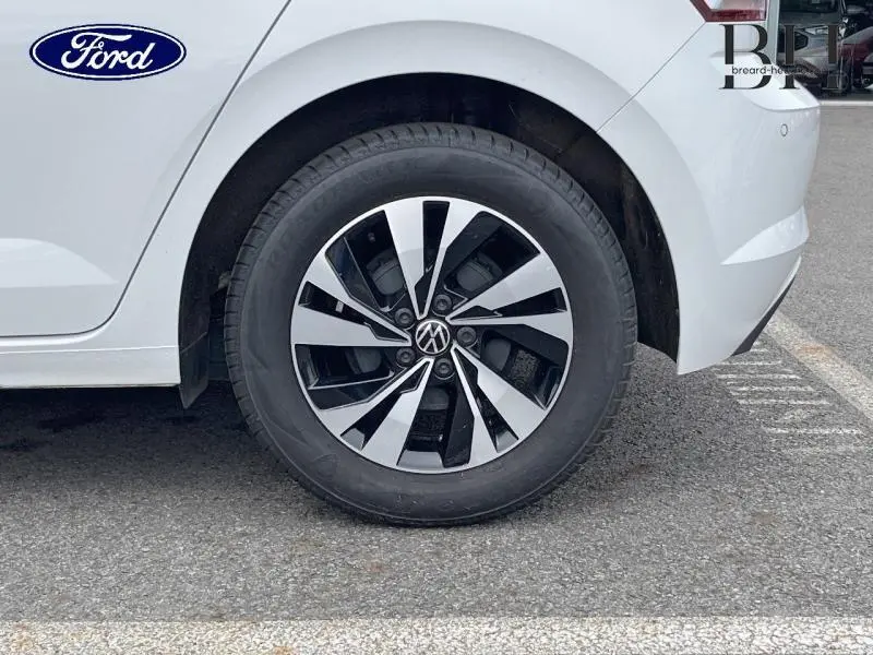 Gros plan sur la roue arrière droite blanche d'une Volkswagen Polo 1.0 TSI avec jante alu bicolore design.