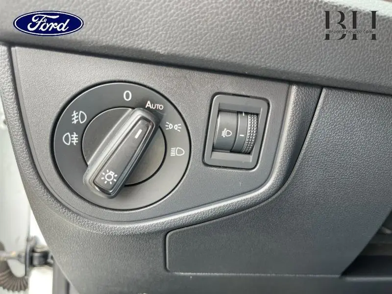 Gros plan sur la commande des phares d'un véhicule, molette noire avec réglage automatique et éclairage antibrouillard.