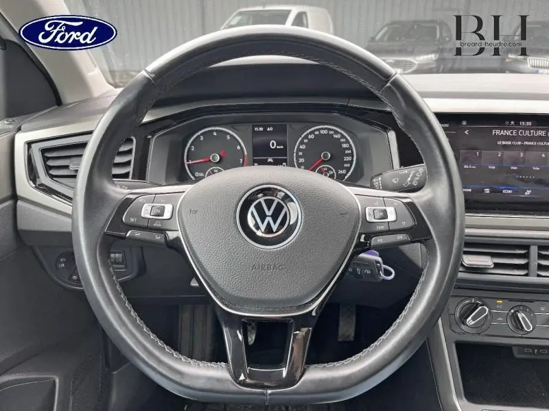 Volant cuir Volkswagen Polo blanc vu de face avec tableau de bord et écran tactile en arrière-plan