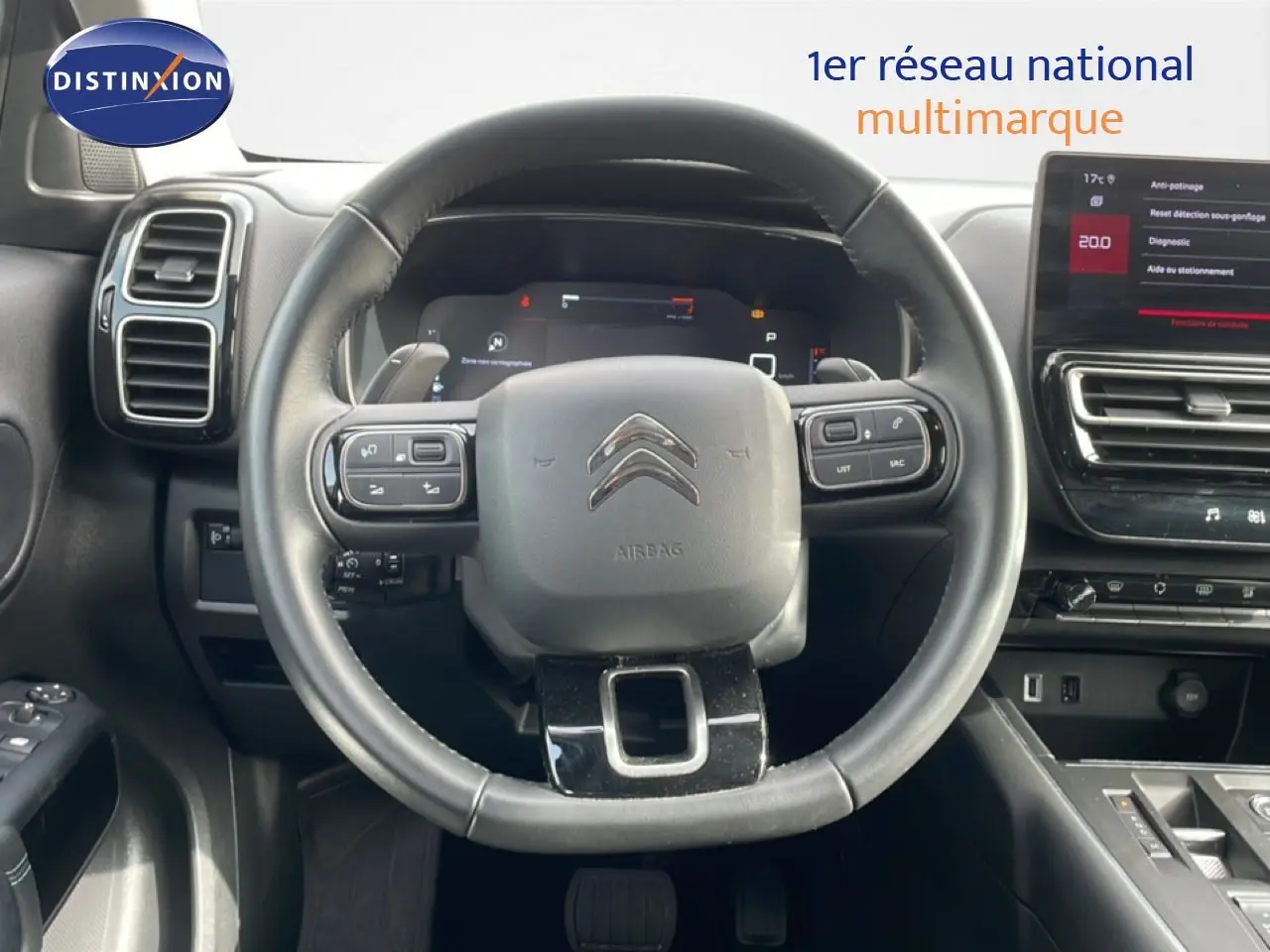 Vue intérieure centrée sur le volant noir du Citroën C5 Aircross 2024 avec tableau de bord digital et écran tactile.