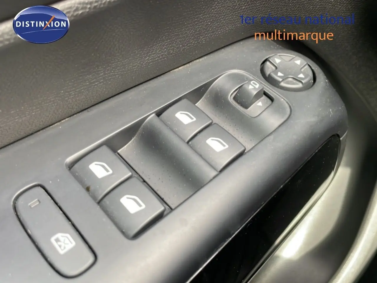 Gros plan sur les commandes des vitres électriques côté conducteur du Citroën C5 Aircross 2024 en intérieur noir.